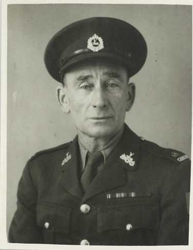 Photo-portrait noir et blanc d’Archie en uniforme peu de temps après son recrutement en 1939. Son visage révèle son âge. Les médailles gagnées durant la Première Guerre mondiale sont visibles sur sa poitrine.